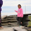A summerday in the arctic: Two girls are playing on a pile of boards in the city of Nuiqsut.
